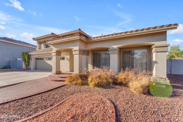 mediterranean / spanish-style home featuring fence, driveway, and stucco siding