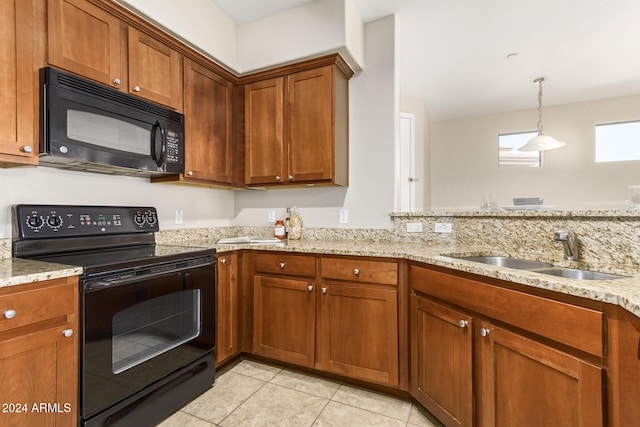 kitchen with light stone countertops, sink, black appliances, light tile patterned floors, and decorative light fixtures