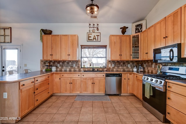 kitchen with tasteful backsplash, appliances with stainless steel finishes, a peninsula, light brown cabinets, and a sink