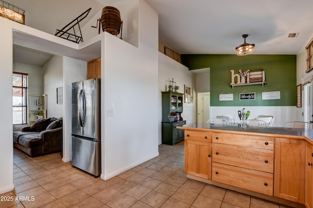 kitchen with freestanding refrigerator, visible vents, dark countertops, and light tile patterned floors