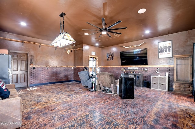 interior space featuring wainscoting, brick wall, ceiling fan, freestanding refrigerator, and recessed lighting