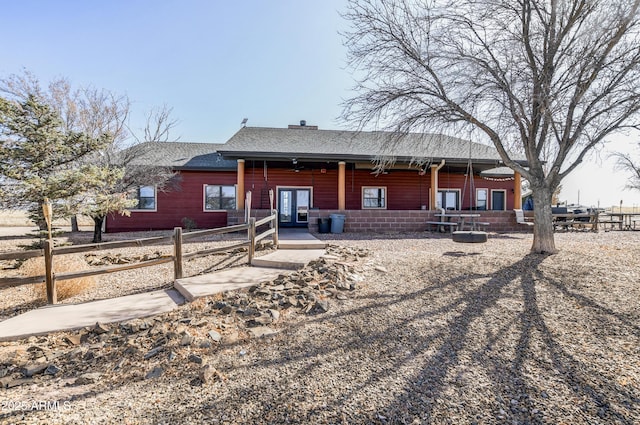 view of front of property featuring a shingled roof, fence, and french doors