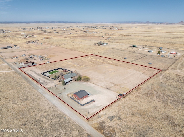 drone / aerial view featuring a mountain view, a desert view, and a rural view