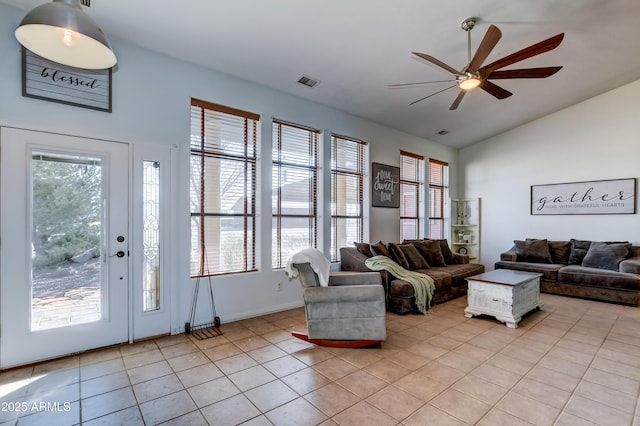 living room with lofted ceiling, a wealth of natural light, light tile patterned flooring, and visible vents