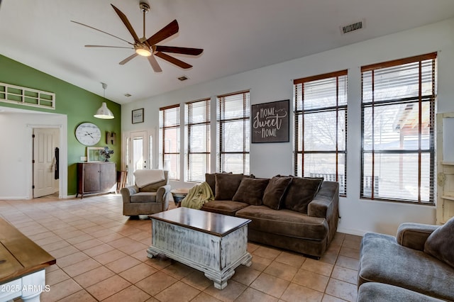 living area with lofted ceiling, light tile patterned flooring, plenty of natural light, and visible vents