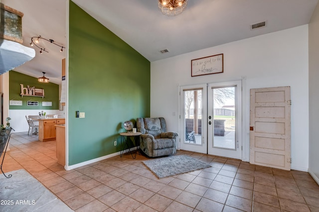 interior space featuring baseboards, visible vents, and light tile patterned flooring