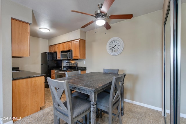 dining room featuring light carpet, ceiling fan, and sink