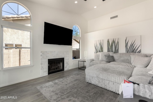 living room featuring ceiling fan, a fireplace, a healthy amount of sunlight, and vaulted ceiling