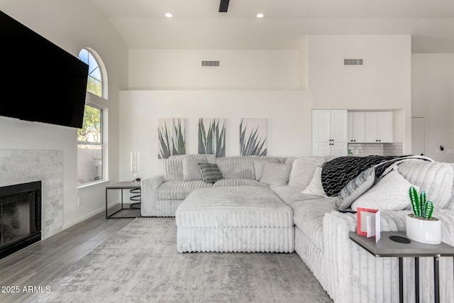 living room with light wood-type flooring and a tile fireplace