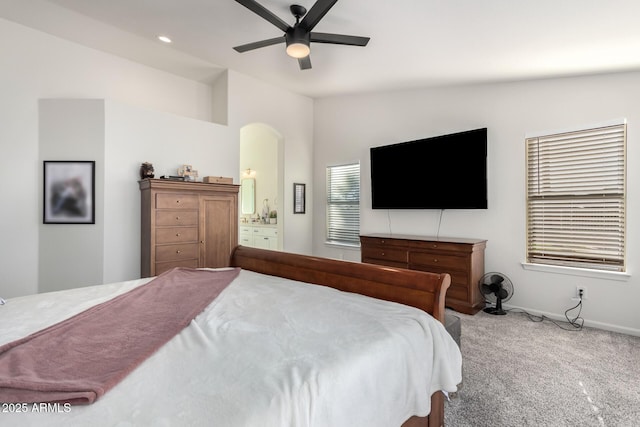 carpeted bedroom featuring connected bathroom, ceiling fan, and vaulted ceiling