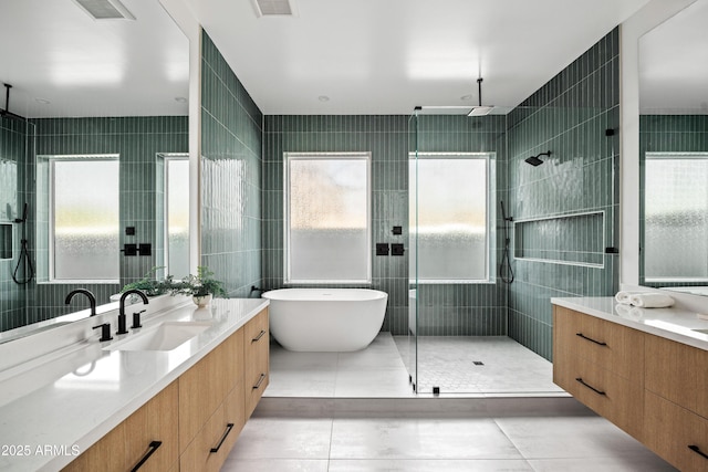 full bath with visible vents, a stall shower, tile walls, a soaking tub, and vanity