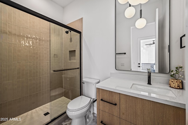 bathroom featuring vanity, toilet, and a shower stall