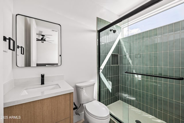 full bath with vanity, toilet, ceiling fan, and a shower stall