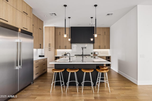 kitchen with visible vents, modern cabinets, and built in fridge