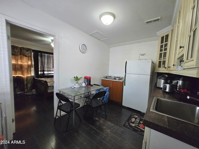 dining room with sink, dark hardwood / wood-style floors, and crown molding