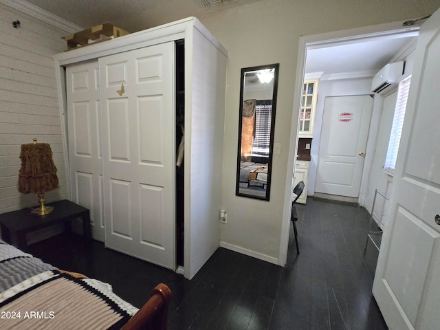 bedroom with wood walls, a wall mounted air conditioner, dark hardwood / wood-style floors, crown molding, and a closet