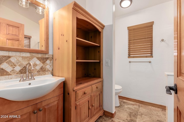 bathroom with vanity, vaulted ceiling, toilet, and tasteful backsplash