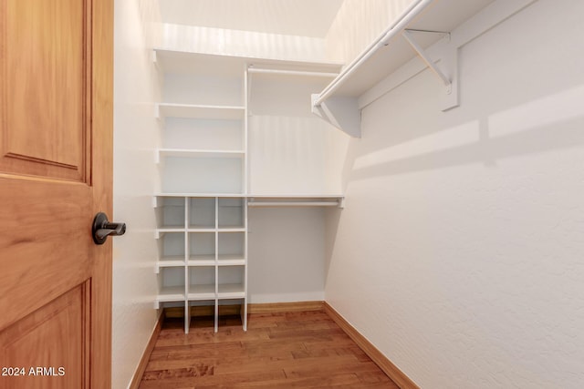 walk in closet with hardwood / wood-style floors