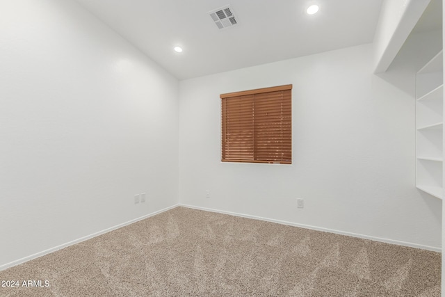 empty room featuring carpet and vaulted ceiling