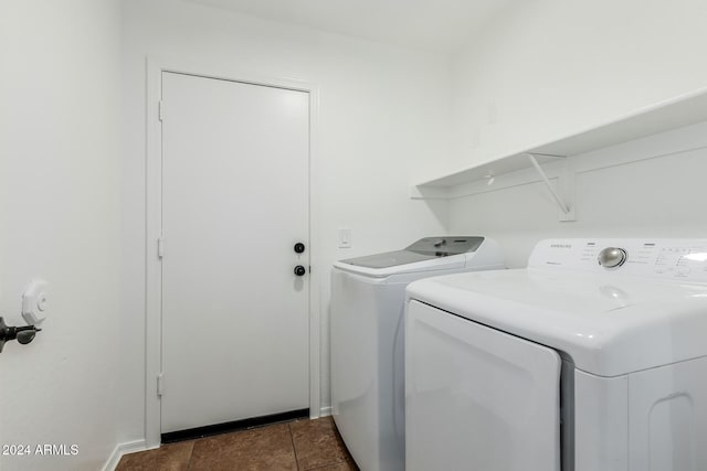 laundry area featuring washing machine and clothes dryer and dark tile patterned floors