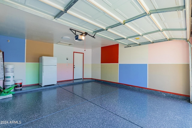 garage with white fridge and a garage door opener