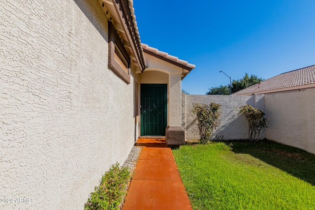 entrance to property featuring a yard