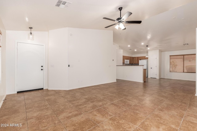 unfurnished living room with ceiling fan and vaulted ceiling