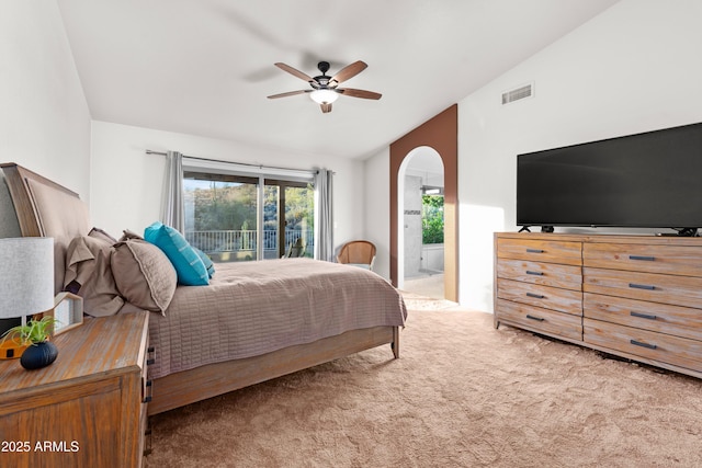 bedroom featuring visible vents, arched walkways, carpet, access to outside, and vaulted ceiling