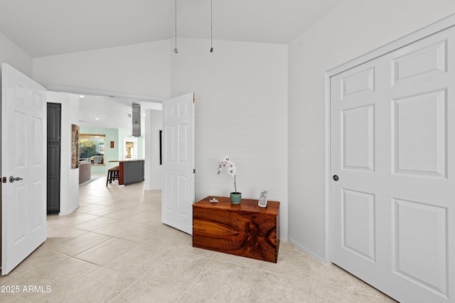 corridor with lofted ceiling and light tile patterned floors