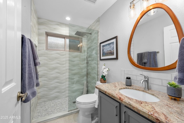 bathroom featuring visible vents, vanity, walk in shower, and toilet