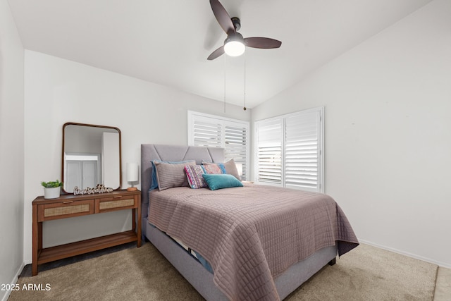 bedroom featuring light carpet, ceiling fan, baseboards, and vaulted ceiling