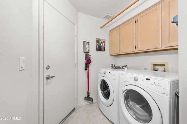 clothes washing area featuring light tile patterned flooring, independent washer and dryer, and cabinet space