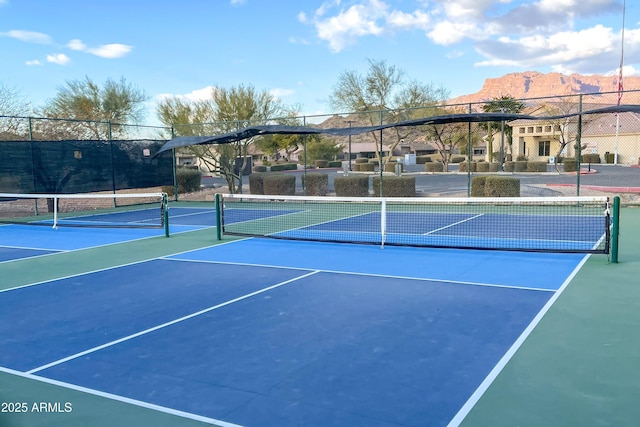 view of sport court with a mountain view and fence