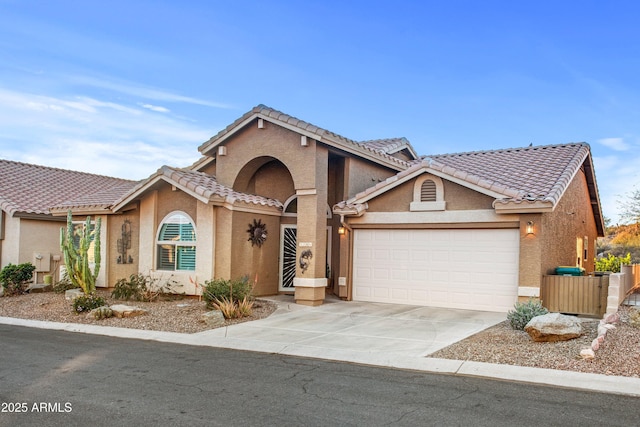 view of front of home with concrete driveway, a tile roof, and stucco siding