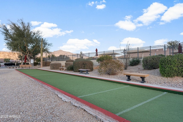 surrounding community with fence and a mountain view