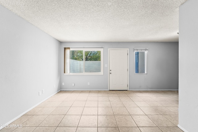 8125 N 32nd Dr, Phoenix, AZ 85051 - spare room with a textured ceiling, baseboards, and light tile patterned floors
