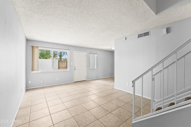 8125 N 32nd Dr, Phoenix, AZ 85051 - empty room with light tile patterned floors, a textured ceiling, and baseboards