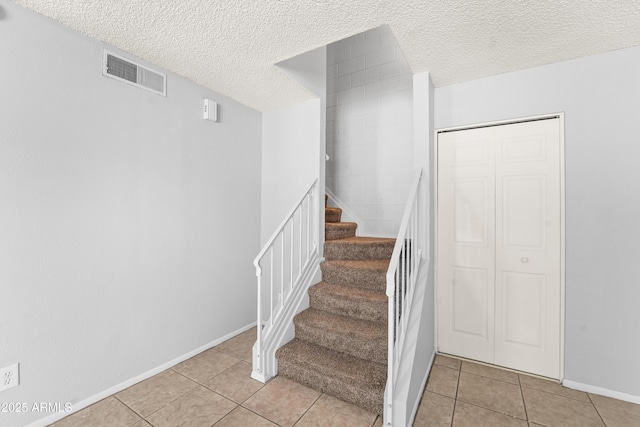 8125 N 32nd Dr, Phoenix, AZ 85051 - stairway with tile patterned flooring, a textured ceiling, and baseboards