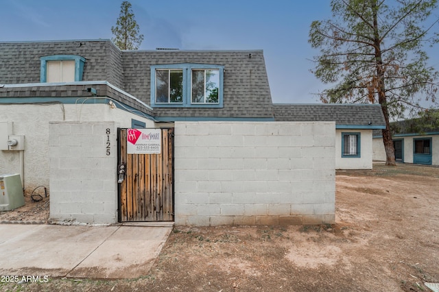 8125 N 32nd Dr, Phoenix, AZ 85051 - view of front facade with a shingled roof, mansard roof, a gate, and a fenced front yard
