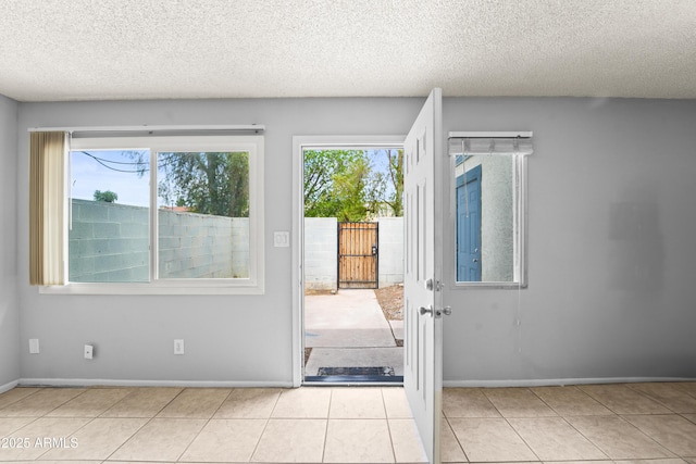 8125 N 32nd Dr, Phoenix, AZ 85051 - doorway to outside with a textured ceiling, baseboards, and tile patterned flooring