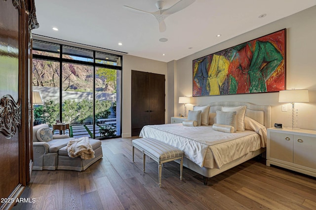 bedroom with ceiling fan, recessed lighting, access to exterior, floor to ceiling windows, and hardwood / wood-style floors