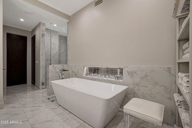 full bath with a freestanding bath, marble finish floor, a marble finish shower, and visible vents