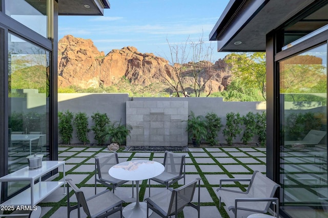 view of patio with fence and a mountain view