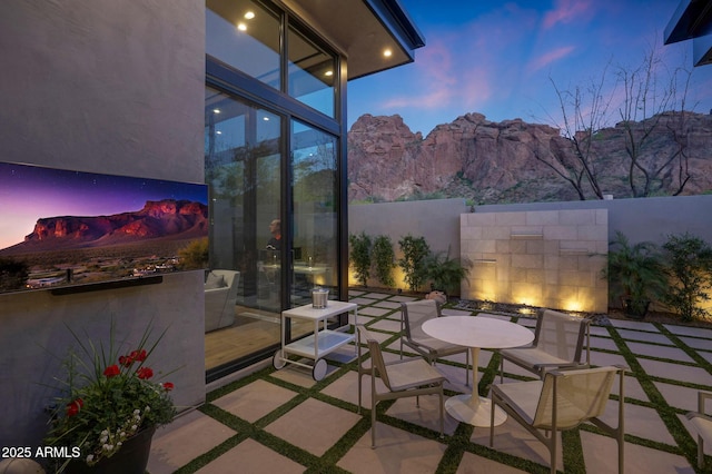 patio terrace at dusk with fence and a mountain view