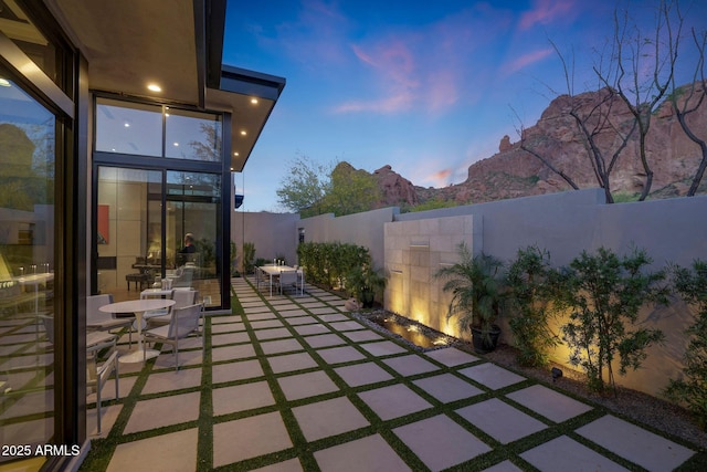 patio terrace at dusk with a fenced backyard