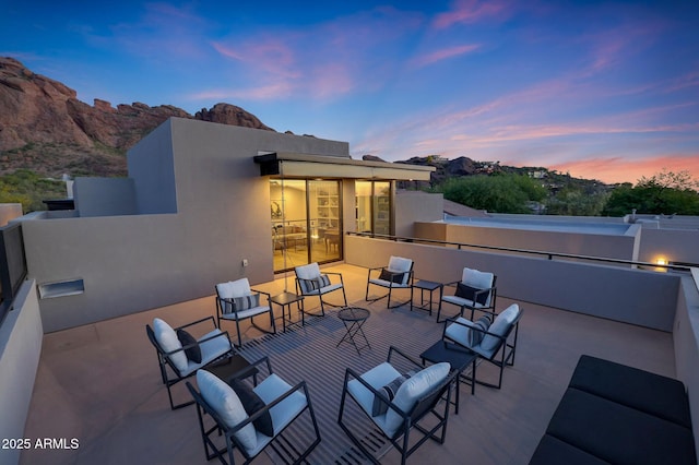 patio terrace at dusk featuring an outdoor hangout area