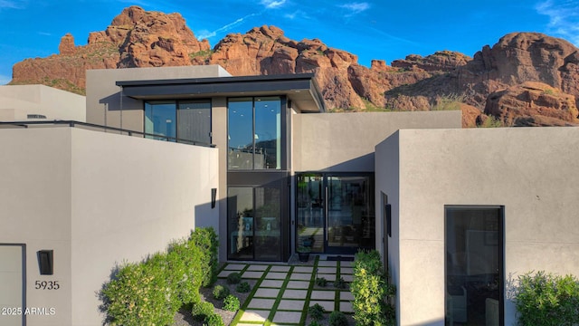 rear view of property featuring stucco siding