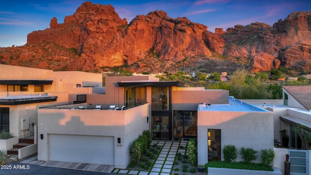 view of front of property with a garage, a mountain view, and stucco siding