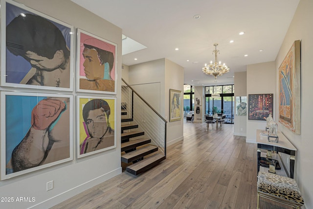 hall with floor to ceiling windows, recessed lighting, stairway, a chandelier, and hardwood / wood-style flooring