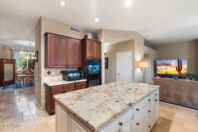 kitchen featuring tasteful backsplash, white cabinetry, black appliances, a notable chandelier, and a center island